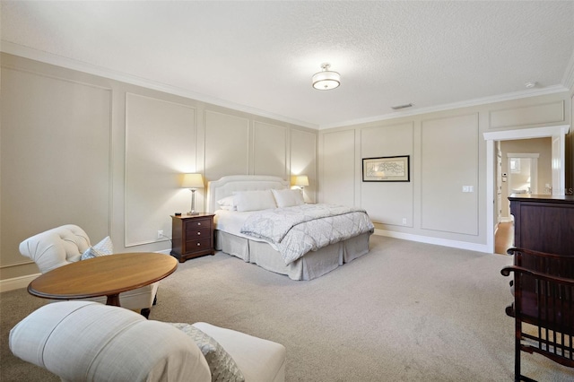 carpeted bedroom featuring a decorative wall, a textured ceiling, crown molding, and visible vents