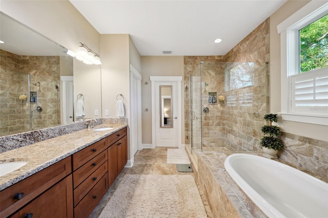 full bathroom with baseboards, double vanity, a stall shower, a sink, and a garden tub