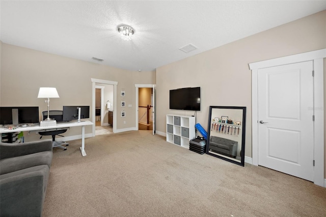 office featuring carpet flooring, baseboards, visible vents, and a textured ceiling