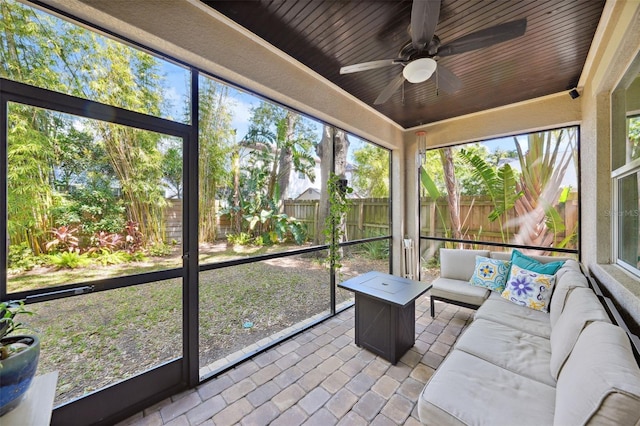 sunroom with wood ceiling and a ceiling fan