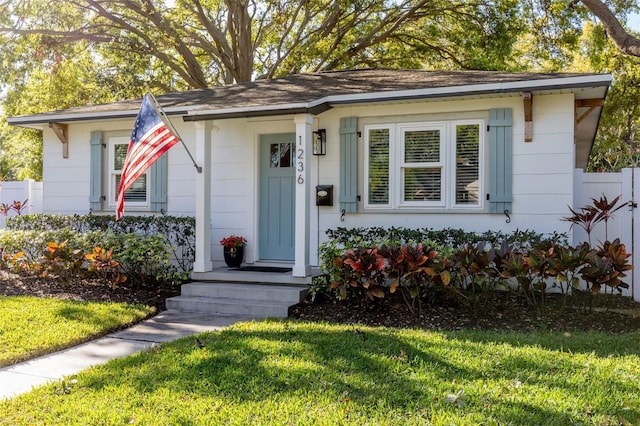 view of front of home with a front yard and fence