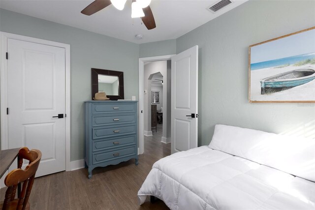 bedroom with visible vents, baseboards, dark wood-type flooring, and a ceiling fan