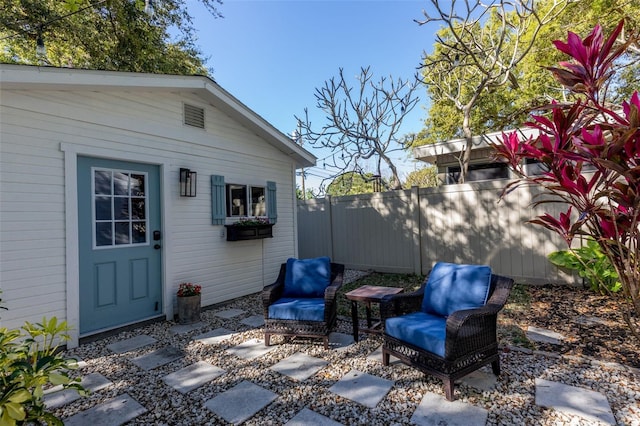 view of patio with an outbuilding and fence