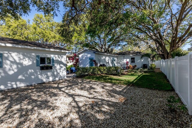 back of property with a lawn and a fenced backyard