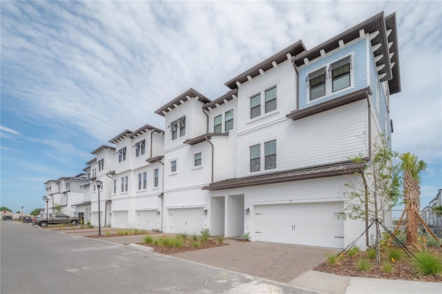 view of front facade featuring a garage, a residential view, and decorative driveway