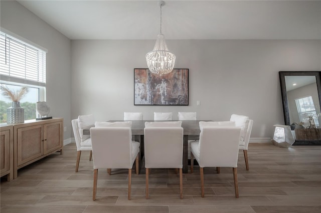 dining space featuring baseboards, an inviting chandelier, and wood tiled floor