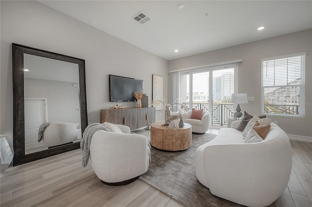 living area featuring recessed lighting, light wood-style floors, visible vents, and baseboards