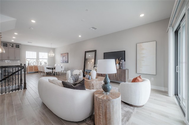 living room with light wood-style flooring, recessed lighting, and visible vents