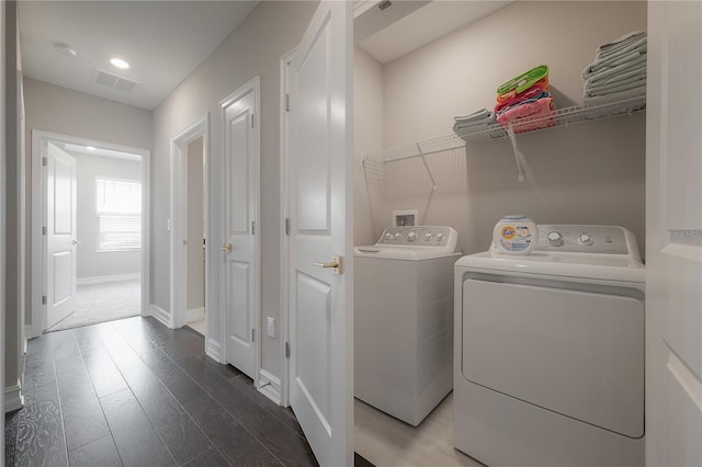 washroom with visible vents, baseboards, laundry area, wood finished floors, and independent washer and dryer