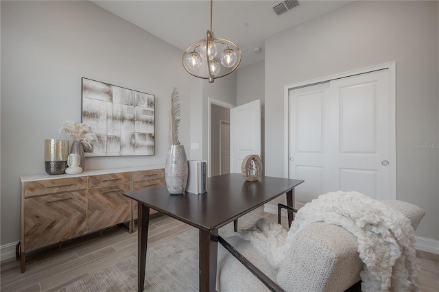 office area with visible vents, baseboards, a notable chandelier, and light wood finished floors