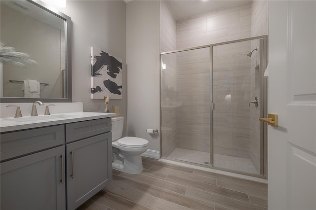 bathroom with wood finish floors, visible vents, toilet, and a stall shower