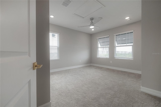 spare room featuring visible vents, baseboards, carpet floors, and attic access