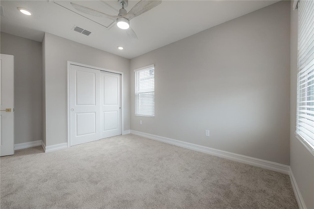 unfurnished bedroom featuring baseboards, visible vents, recessed lighting, a closet, and light carpet