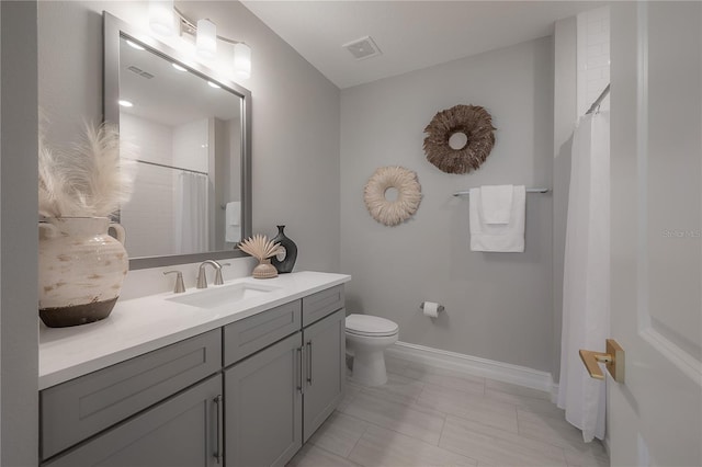 bathroom with vanity, a shower with curtain, baseboards, visible vents, and toilet