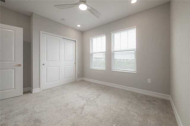 unfurnished bedroom featuring a closet, recessed lighting, carpet, and baseboards