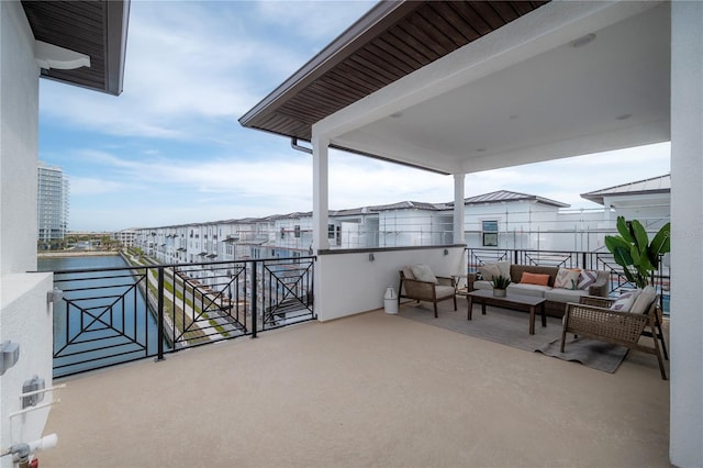 view of patio / terrace with an outdoor living space, a balcony, and a water view