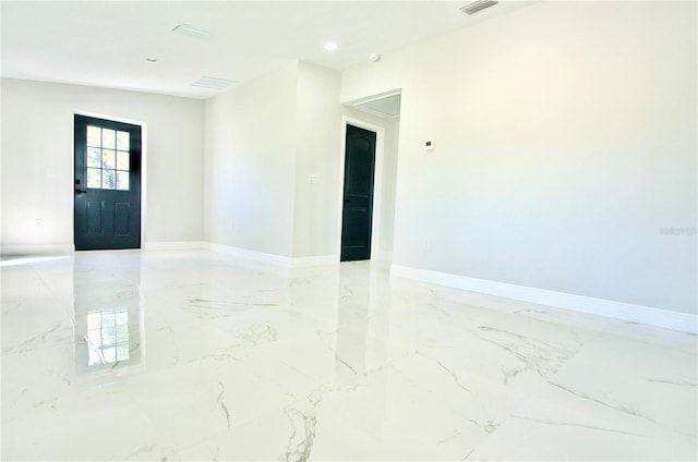 unfurnished room featuring baseboards and marble finish floor