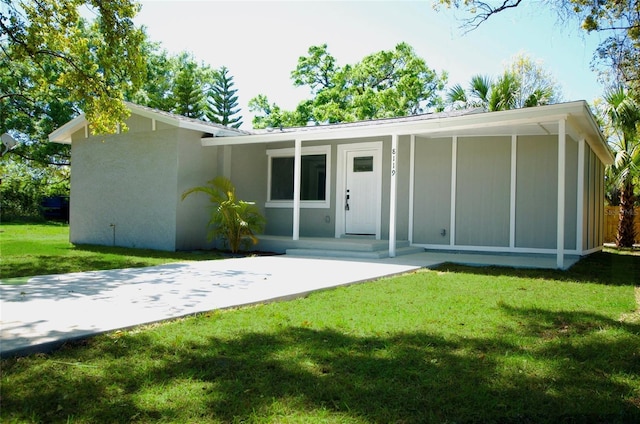 rear view of house with a porch and a yard