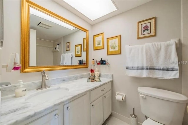 bathroom with visible vents, toilet, a skylight, and vanity