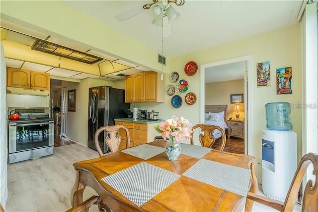 dining space featuring a ceiling fan, light wood-style floors, and visible vents