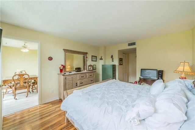 bedroom with visible vents, light wood-style flooring, and baseboards