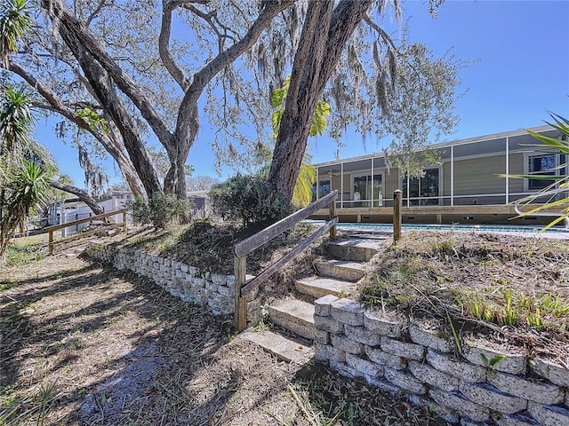 rear view of property featuring glass enclosure and an outdoor pool