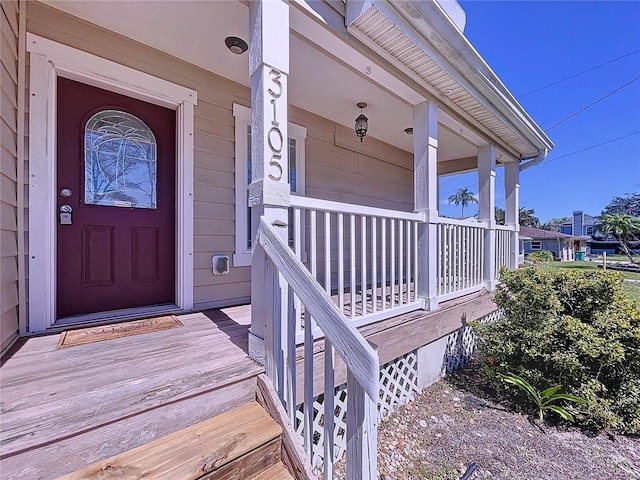 view of exterior entry featuring covered porch