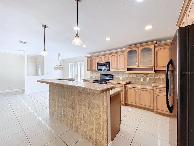 kitchen with light tile patterned floors, backsplash, black appliances, and light countertops