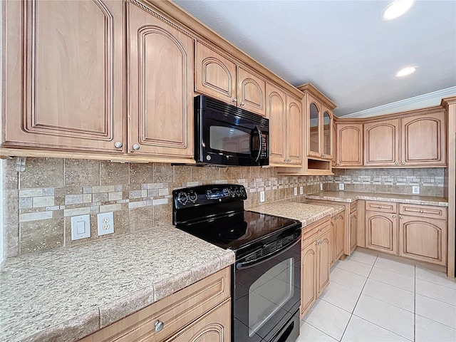 kitchen featuring light tile patterned flooring, black appliances, light countertops, glass insert cabinets, and tasteful backsplash