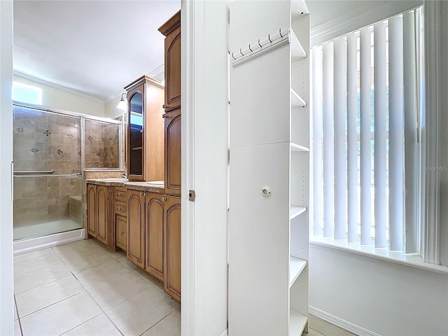 bathroom with vanity, tile patterned floors, a stall shower, and ornamental molding