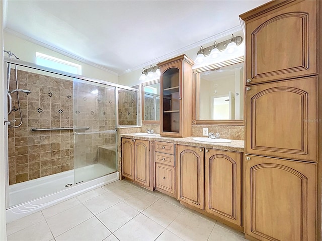 full bathroom featuring a sink, a stall shower, tile patterned floors, and ornamental molding