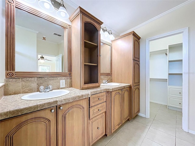 bathroom with a sink, ornamental molding, and double vanity