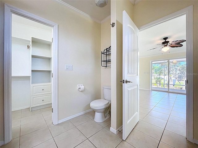 bathroom with tile patterned floors, toilet, crown molding, and baseboards