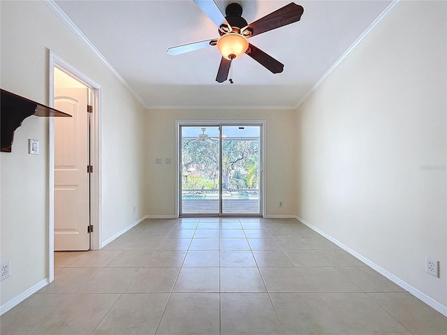 spare room with light tile patterned floors, baseboards, ornamental molding, and a ceiling fan