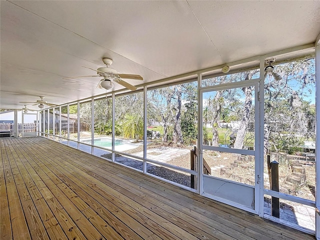 unfurnished sunroom with ceiling fan