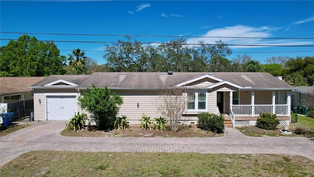 ranch-style home featuring fence, covered porch, driveway, crawl space, and an attached garage