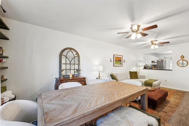 bedroom with baseboards, freestanding refrigerator, a ceiling fan, and wood finished floors