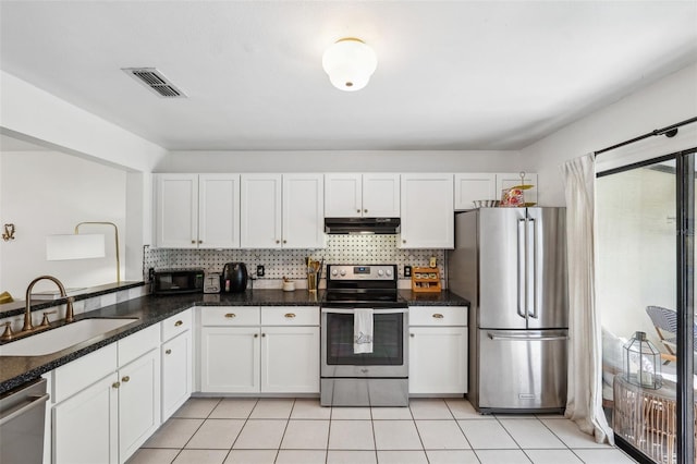 kitchen featuring visible vents, extractor fan, decorative backsplash, stainless steel appliances, and a sink