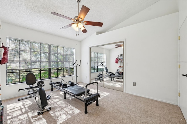 exercise room with a textured ceiling, vaulted ceiling, carpet floors, and ceiling fan