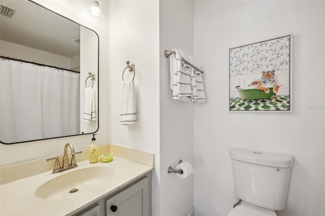 bathroom featuring visible vents, toilet, and vanity