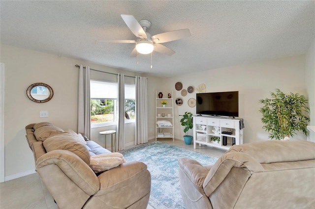 living area featuring a ceiling fan, baseboards, and a textured ceiling