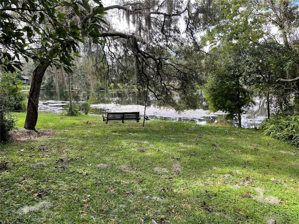 view of community featuring a water view and a lawn