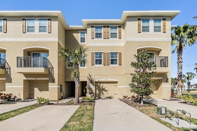 multi unit property with stucco siding, driveway, and a garage