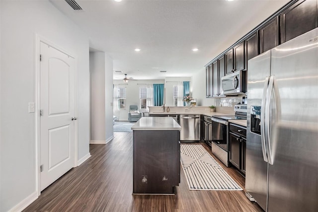 kitchen featuring visible vents, dark wood finished floors, light countertops, appliances with stainless steel finishes, and a center island