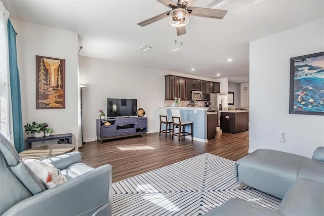 living room with recessed lighting, visible vents, a ceiling fan, and dark wood-style flooring