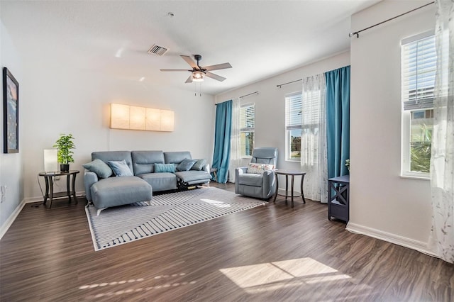 living room with a ceiling fan, wood finished floors, visible vents, and baseboards