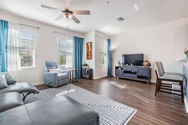 living room with a ceiling fan, wood finished floors, visible vents, and baseboards