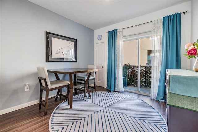 dining area with baseboards and wood finished floors