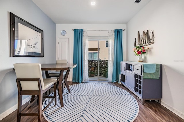 dining room with visible vents, baseboards, and dark wood-type flooring