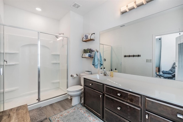 full bath featuring visible vents, toilet, a stall shower, wood finished floors, and vanity